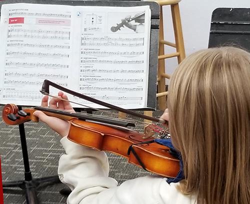 Highland Hall students practicing string instruments in music class.